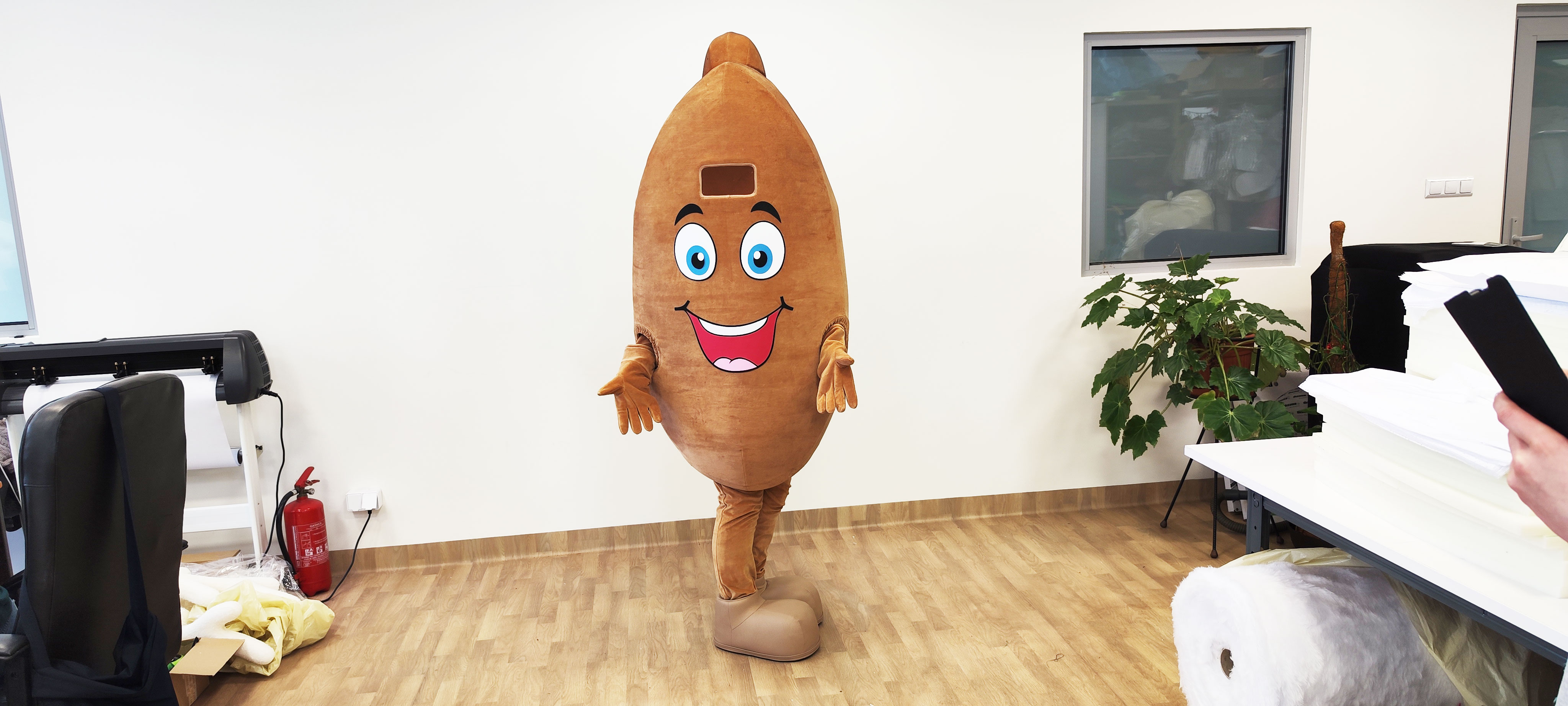 Na fotografii widnieje strój reklamowy w postaci pieroga pozujący do zdjęcia w siedzibie firmy Elabika